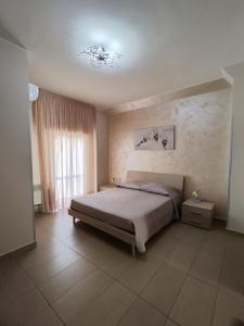 a bedroom with a large bed and a window at Albergo Primavera in Porto Cesareo