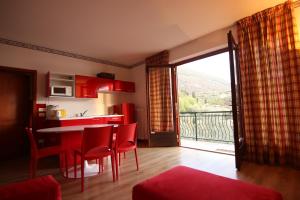 a kitchen with a table and chairs and a balcony at red house conditioned whit pool enchanting lake view in Malcesine