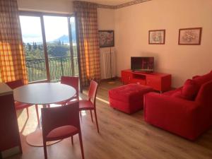 sala de estar con sofá rojo y mesa en red house apartments whit enchanting lake view, en Malcesine