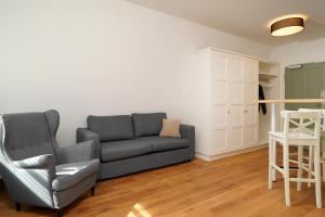 a living room with a couch and a chair at Palmbräu Altstadt Appartments in Heidelberg