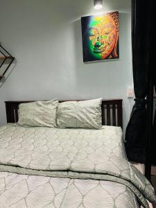 a bed in a bedroom with a painting on the wall at MILD ROOM SEA VIEW ROOM FOR RENT in Phi Phi Don