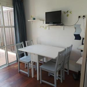 a white dining room table with chairs and a television at Studio 4P Vue Mer Calme Cap Esterel in Saint-Raphaël