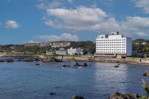 a large white building in front of a body of water at 銚子グランドホテル in Choshi