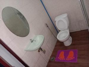 bagno con lavandino, servizi igienici e specchio di 4jMarte Home Stay a Imus