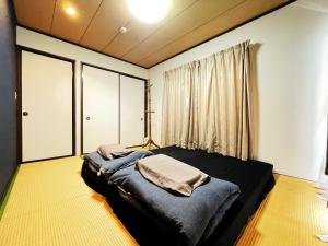 a bedroom with a bed in a room with a window at Estate F 201 in Kamatachō