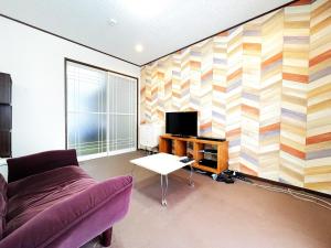 a living room with a couch and a tv at Estate F 201 in Kamatachō