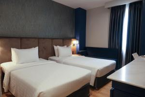 een hotelkamer met 2 bedden en een bureau bij Nicecy NganHa Hotel in Ho Chi Minh-stad