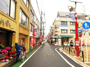 a man riding a bike down a city street at Estate F 201 in Kamatachō