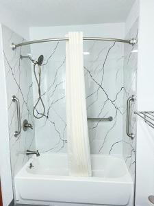 een badkamer met een douche met een wit douchegordijn bij Super 8 by Wyndham Peoria in Peoria