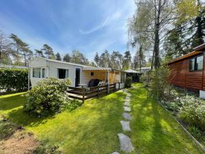 een verbouwde caravan met een tuin en een huis bij Forest Feelings - op 5 sterren park met heerlijke privé tuin in Beekbergen