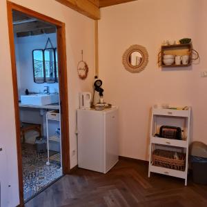 a kitchen with a sink and a refrigerator and a mirror at La Longère d'Ecottes in Licques