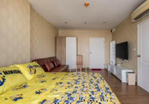een slaapkamer met een groot geel bed en een televisie bij The tree bang po station in Bang Su