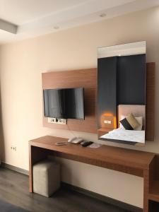 sypialnia z lustrem, łóżkiem i telewizorem w obiekcie Carpe Diem Hotel w mieście Ayvalık