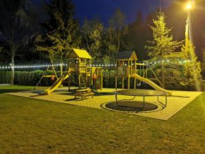 博爾沙的住宿－POPASUL LU' VODĂ，公园里的一个游乐场,晚上有灯光