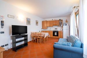 a living room with a blue couch and a kitchen at Agriturismo Ca' Marcello in Mira