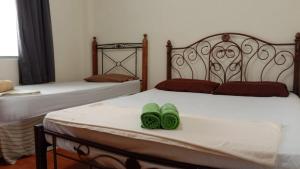 two beds with green slippers sitting on top of them at Colobeentoi Three Bedroom Sea View in Port Dickson