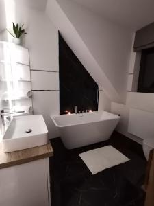 y baño con bañera blanca y lavamanos. en Chillout House Serwy, en Serwy