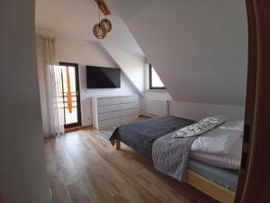 a small bedroom with a bed and a television at Chillout House Serwy in Serwy