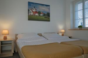 sypialnia z 2 łóżkami i zdjęciem na ścianie w obiekcie Willa Centrum w Supraślu