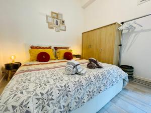 - une chambre avec un grand lit et des oreillers jaunes dans l'établissement L'appartement du Temple à Vienne, à Vienne
