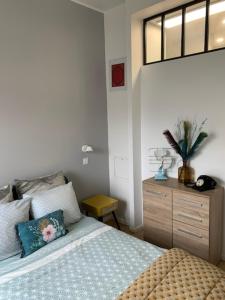 1 dormitorio con cama y tocador de madera en Appartement contemporain jardin & jacuzzi en Voisins-le-Bretonneux