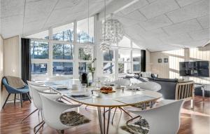 a dining room with a table and chairs at Holiday Home Hybenvangen Oksbøl Denm in Oksbøl