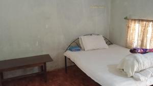 a small bedroom with two beds and a table at Chital lodge in Chitwan