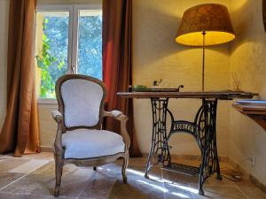 ル・ボーセにあるLe mas des escansのテーブル、椅子、ランプが備わる部屋