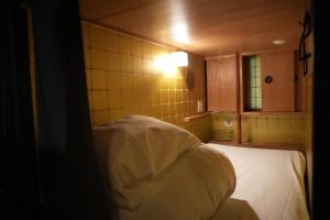 a room with a bed and a kitchen with a light at Guest House Tokyo Samurai in Tokyo
