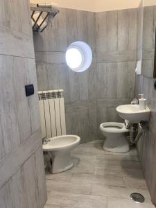 a bathroom with two toilets and a sink and a light at Tuanis in Naples +50 photos