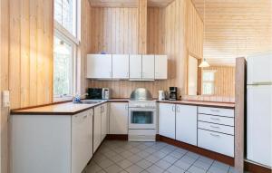 a kitchen with white appliances and wooden walls at Rubinsen Skovhus in Hasle