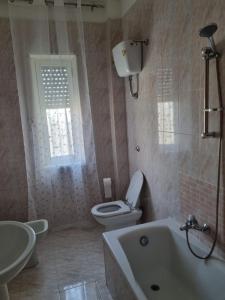 a bathroom with a toilet and a sink and a tub at Casa vacanza yolo in Macerata Campania