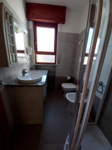 a bathroom with two toilets and a sink and a window at Villa Adria in Lignano Sabbiadoro
