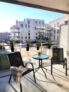 a patio with a table and chairs on a balcony at Apartament DanHouse in Giżycko