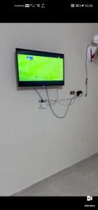 TV de pantalla plana colgada en la pared en القاهره, en El-Sa`âida