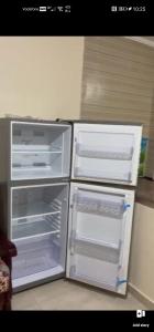 an empty refrigerator with its doors open in a kitchen at القاهره in El-Sa`âida