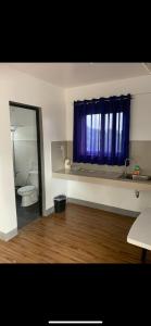 a bathroom with a toilet and a blue curtain at Chillax Inn in Tagaytay