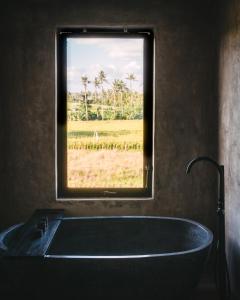 uma banheira na casa de banho com uma janela em DABA - Designer Villas in Perenenan - Beach 600M em Canggu