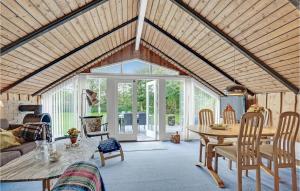 HalsにあるAwesome Home In Hals With 3 Bedroomsの木製の天井とテーブル付きのリビングルーム