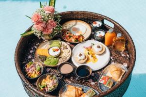 einen Korb mit Frühstückszutaten auf dem Tisch in der Unterkunft La Miniera Pool Villas Pattaya - SHA Plus in Nong Prue