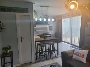 cocina y sala de estar con mesa y sillas en petite maison cosy en duplex, en Éguelshardt