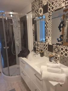 a bathroom with a shower and a sink with towels at petite maison cosy en duplex in Éguelshardt