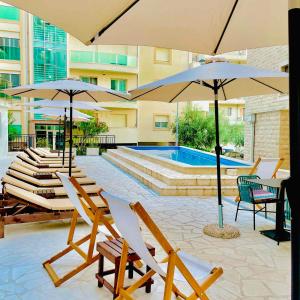a patio with chairs and umbrellas and a swimming pool at Garni Hotel Casa di Sofia in Budva