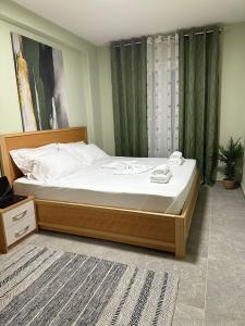 ein Schlafzimmer mit einem großen Bett mit weißer Bettwäsche in der Unterkunft Ermar Apartment in Golem