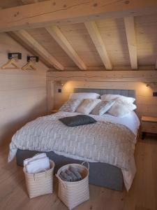 a bedroom with a bed with two baskets at Chalet neuf La Perle du Perron in Cordon