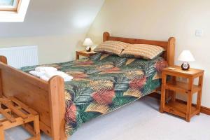 ein Schlafzimmer mit einem Bett und zwei Nachttischen in der Unterkunft Cae Coryn Cottages, Snowdonia ( Troed y Graig ) in Bala