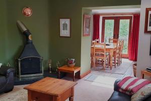 a living room with a fireplace and a dining room at Cae Coryn Cottages, Snowdonia ( Troed y Graig ) in Bala