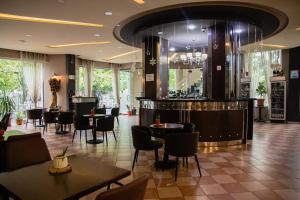 un ristorante con tavoli e sedie e un bar di Hotel Blini a Shkodër