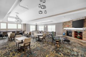a dining room with tables and chairs and a fireplace at Residence Inn Hartford Rocky Hill in Rocky Hill