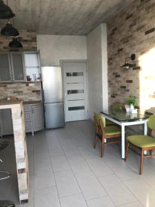 a kitchen with a table and a refrigerator at Apart Plaza 24 in Kyiv